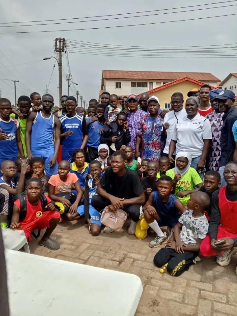 A big group of young boxers, coaches and families lined up together outdoors